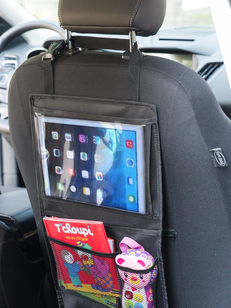 Auto-Organizer an der Rückseite des Vordersitzes mit Tablet in der transparenten Tasche und gefüllten Netztaschen